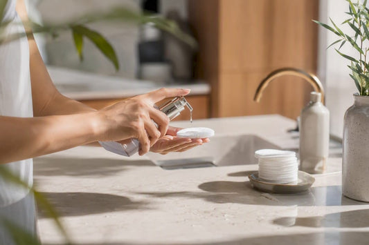 Hand dispensing paraben-free serum on bathroom counter