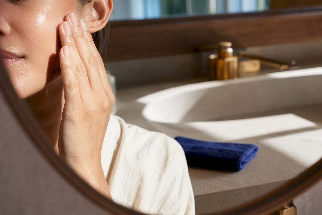 Moisturizer being pressed into damp cheek skin