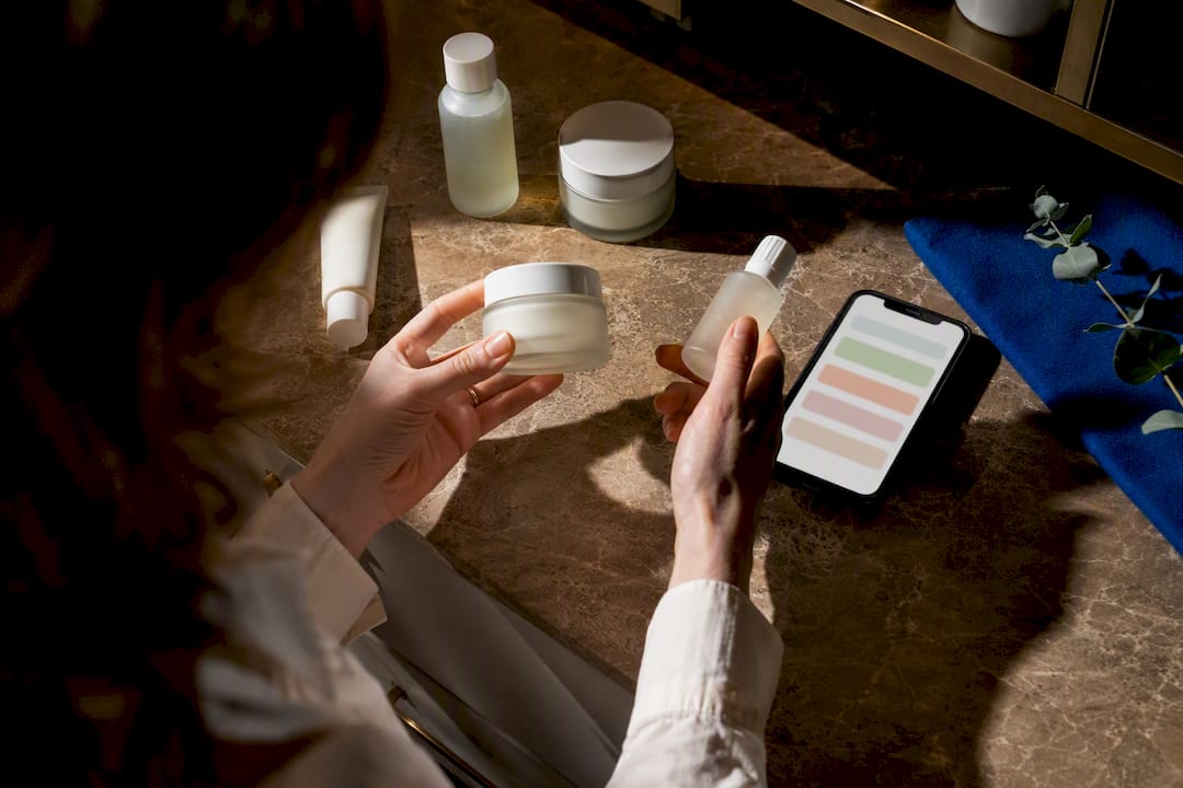 Hands reviewing anonymous skincare ingredient labels