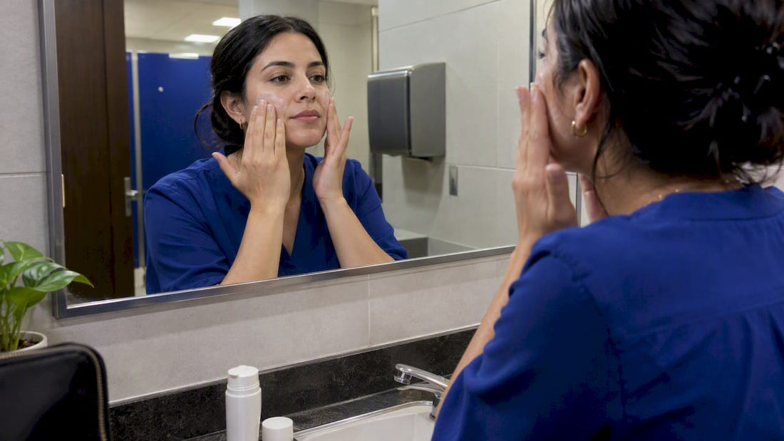 Woman gently applying sunscreen over makeup